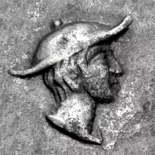 Representación de una cabeza con Kapsa, al estilo del Hermes griego, en una moneda macedonia del 400 a. C. Representación de una cabeza con Kapsa, al estilo del Hermes griego, en una moneda macedonia del 400 a. C.